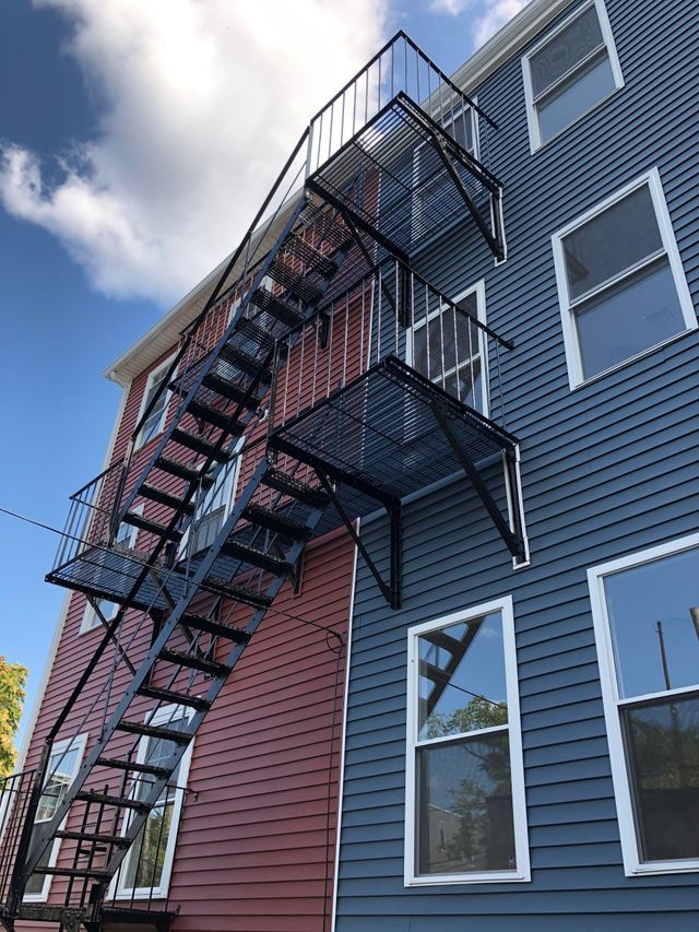 A fire escape is attached to the side of a building.