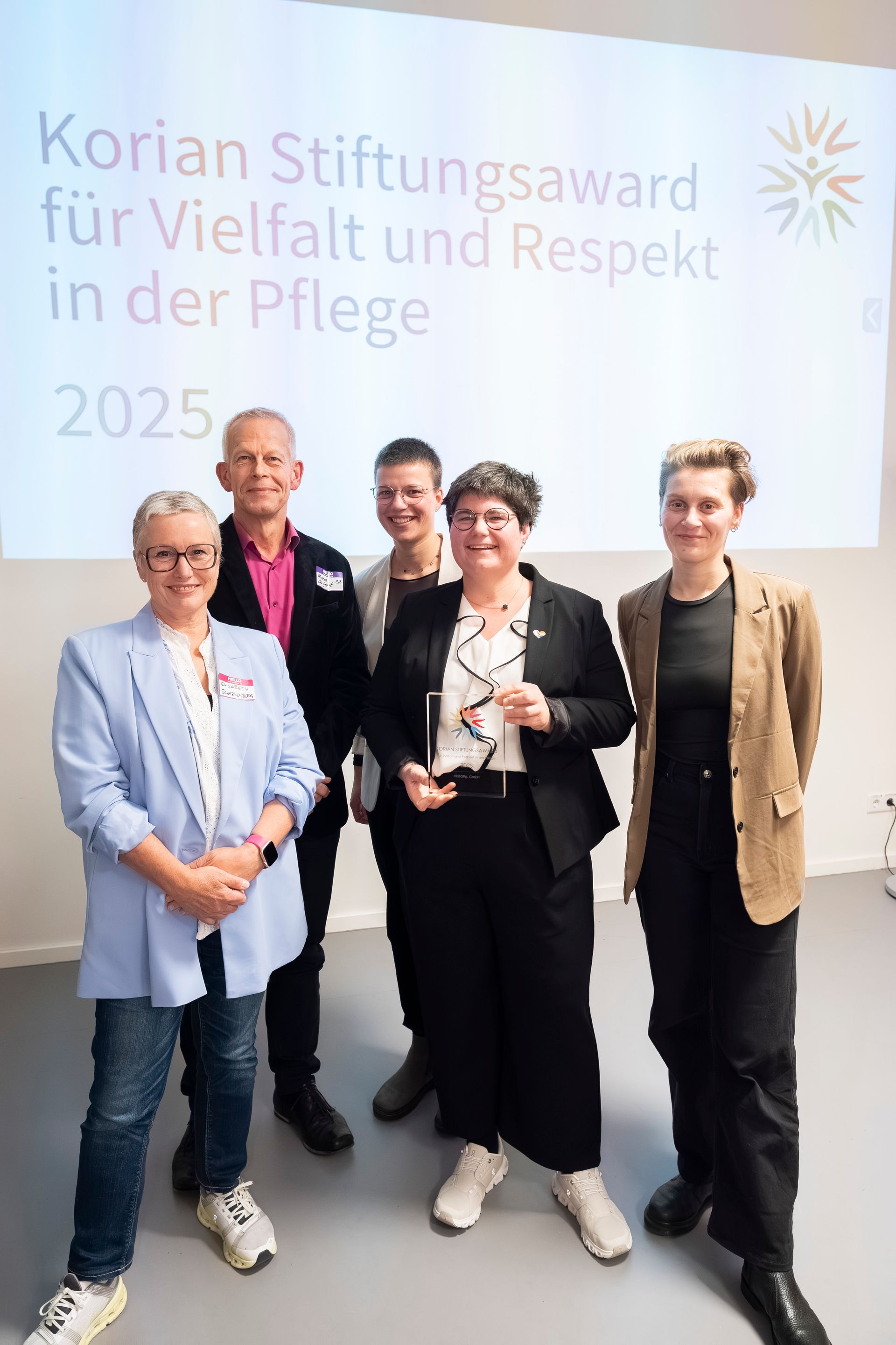 Silhouetten einer Gruppe mit dem Logo des Stiftungsawards 2026 mit dem Untertitel: Korian Stiftungsaward 2026 mit eurer Einrichtung?