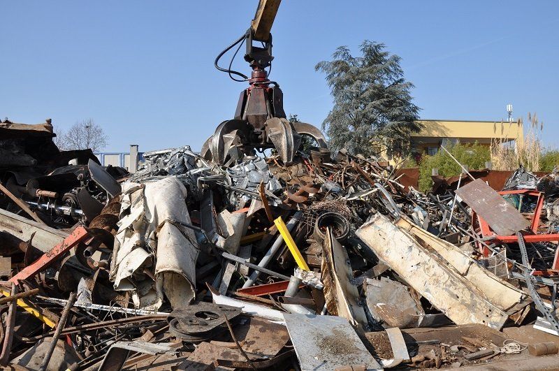 bulldozer con braccio meccanico che afferra i materiali dismessi
