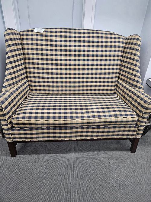 A black and white checkered couch is sitting on a rug.