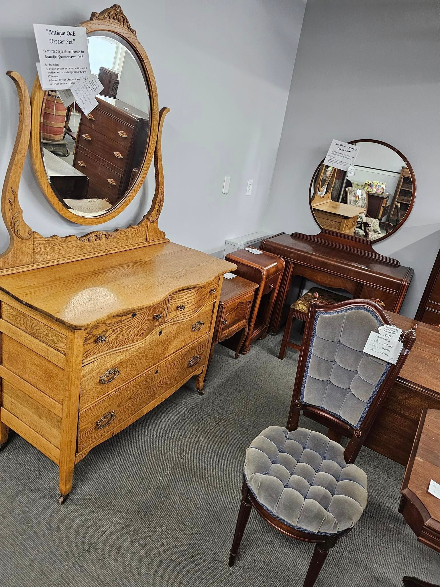 A room with a dresser , chairs , and a mirror.