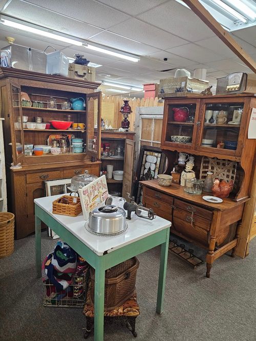 A room filled with lots of antique furniture and a table.