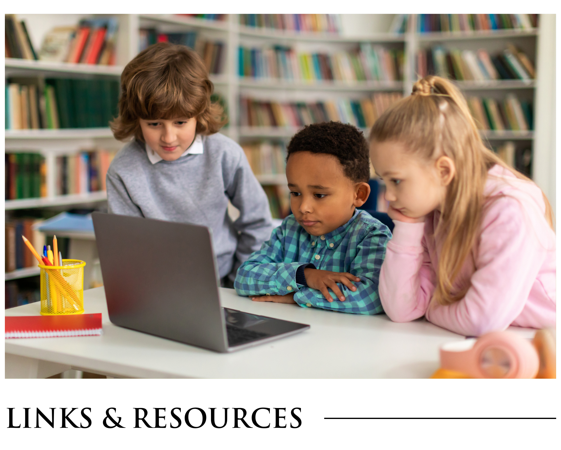 A group of children are sitting at a table looking at a laptop computer.