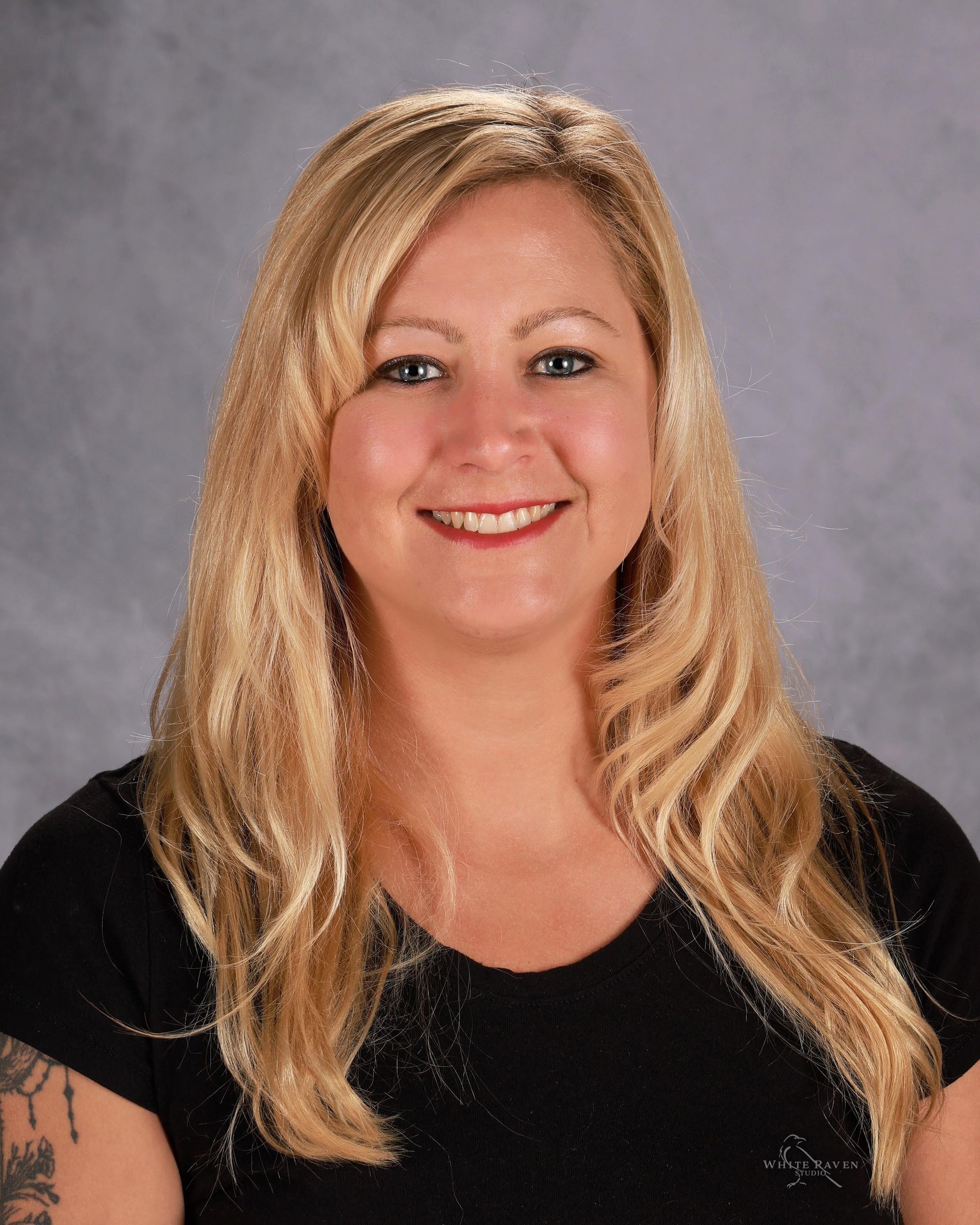 A woman in a black shirt is smiling for a picture.
