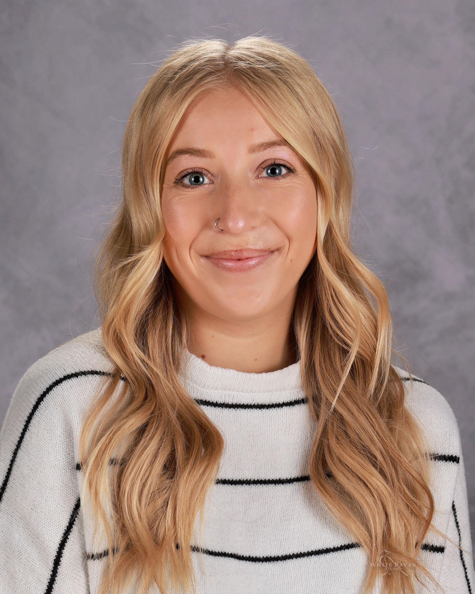 A young woman with blonde hair is smiling for a picture.