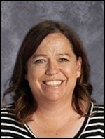 A woman in a black and white striped shirt is smiling for the camera.
