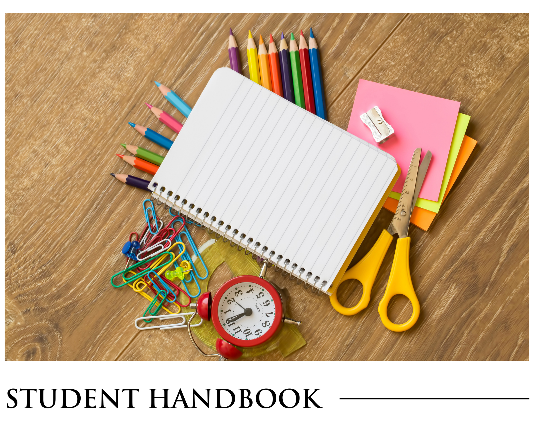 A student handbook with school supplies on a wooden table