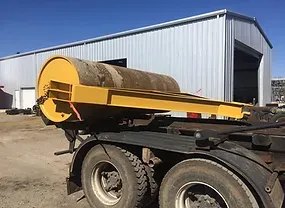 a yellow roller is attached to the back of a truck .