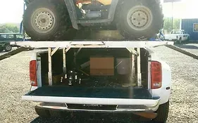 an atv is sitting on top of a white truck .