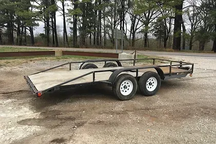 a trailer is parked on the side of the road in a parking lot .