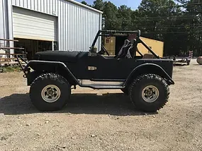 a black jeep is parked in front of a garage .