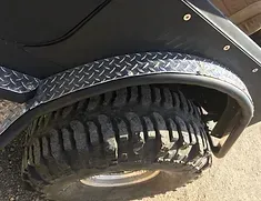 a close up of a tire on a jeep with fender flares .