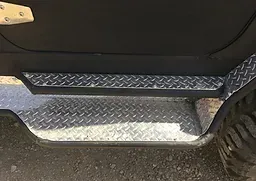 a close up of a metal step on a golf cart .
