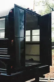 the back of a black bus with the door open .