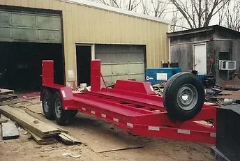 a red trailer is parked in front of a garage