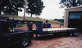 a flatbed trailer is parked in front of a garage
