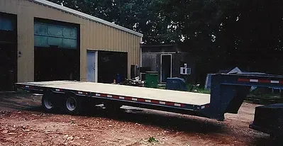 a flatbed trailer is parked in front of a building