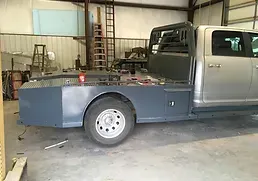 a truck with a flat bed is sitting in a garage .