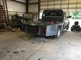 a truck is parked in a garage next to a lawn mower .
