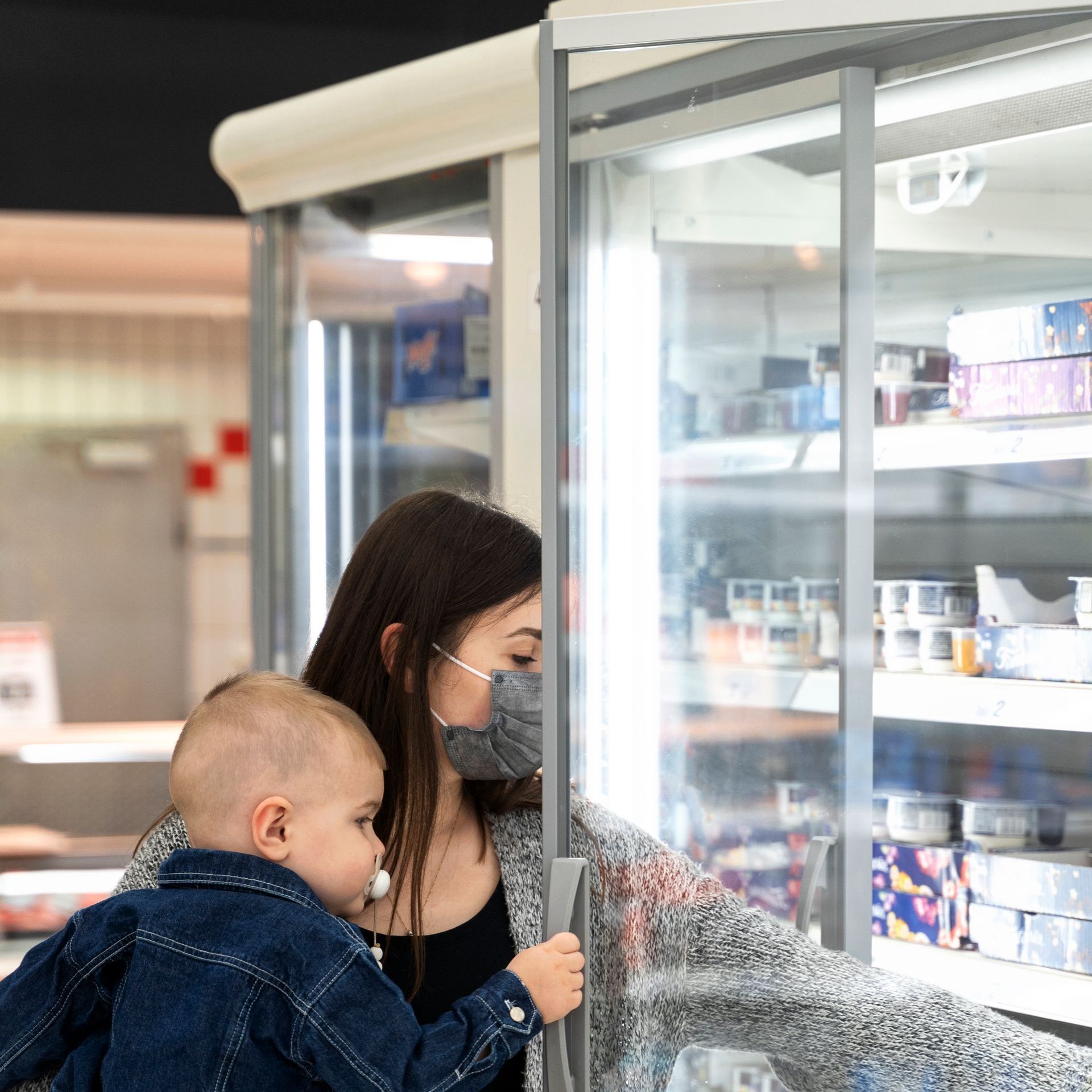 woman with kid using commercial refrigerator