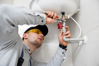 worker repairing hot water tank