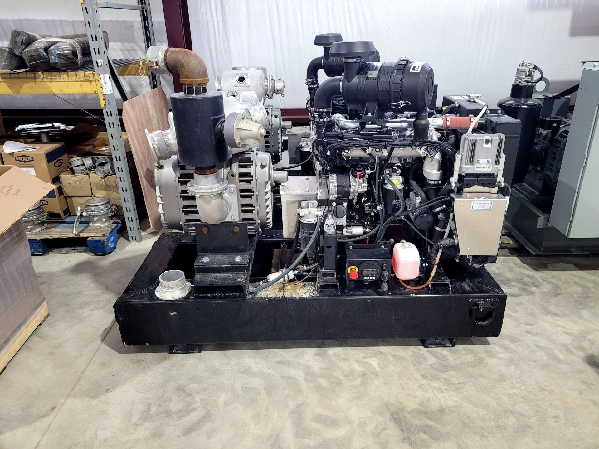 A large engine is sitting on top of a concrete floor in a warehouse.