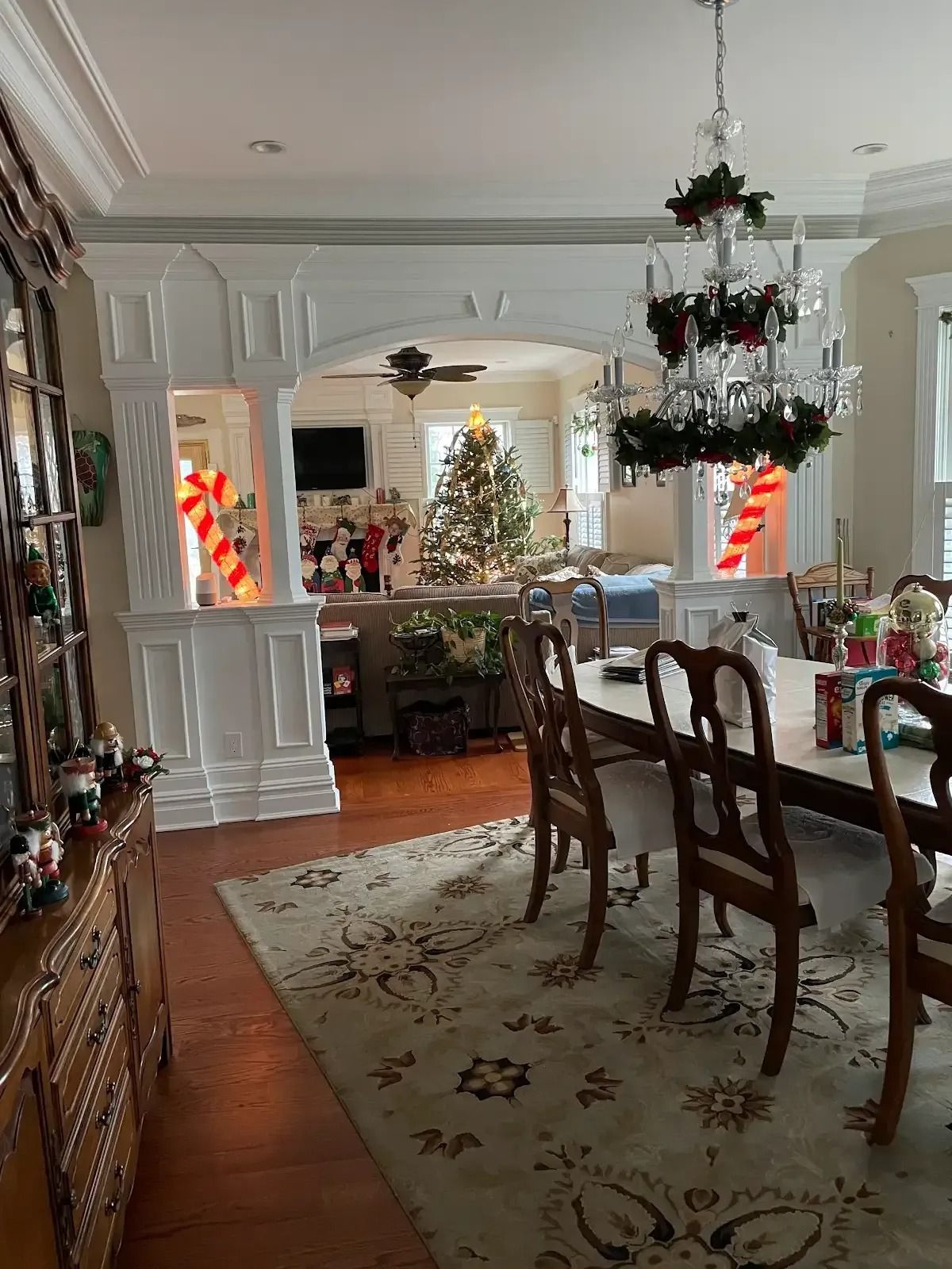 A dining room with a table and chairs and a christmas tree in the background