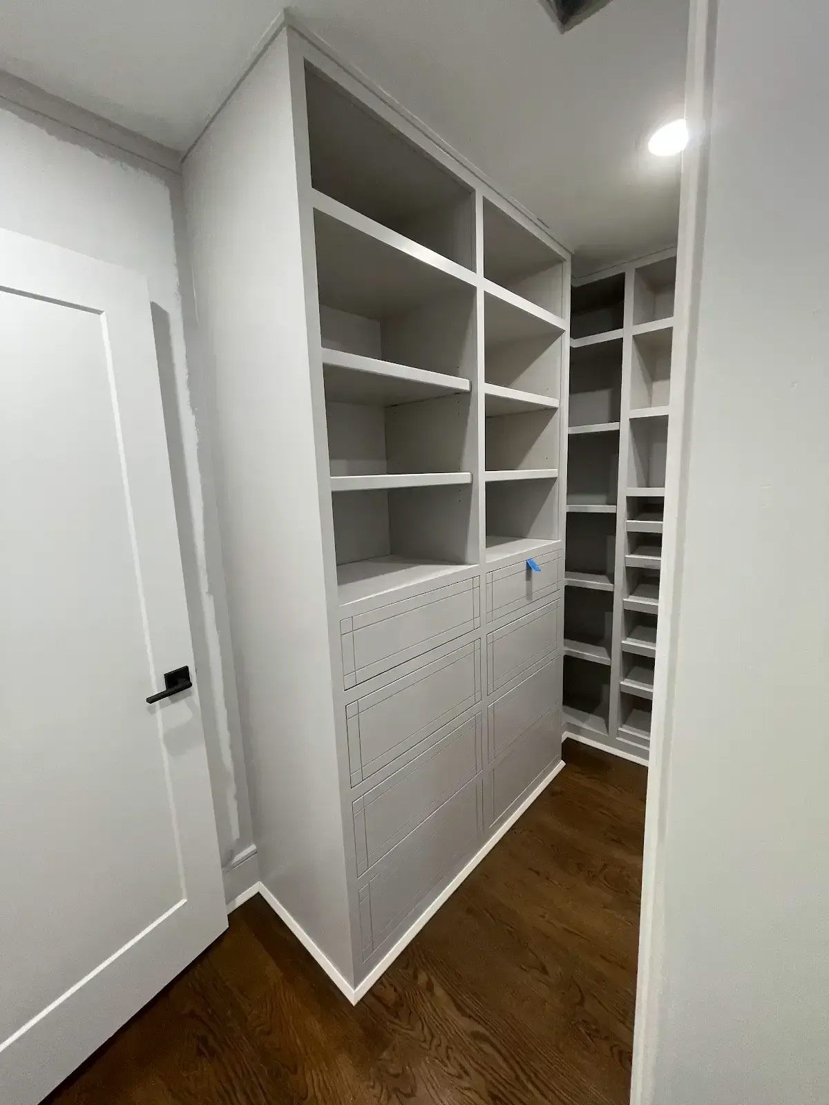 A walk in closet with lots of shelves and drawers