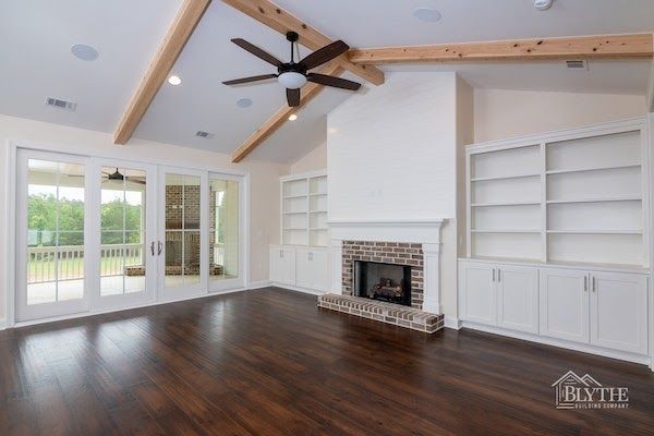A living room with a fireplace and a ceiling fan