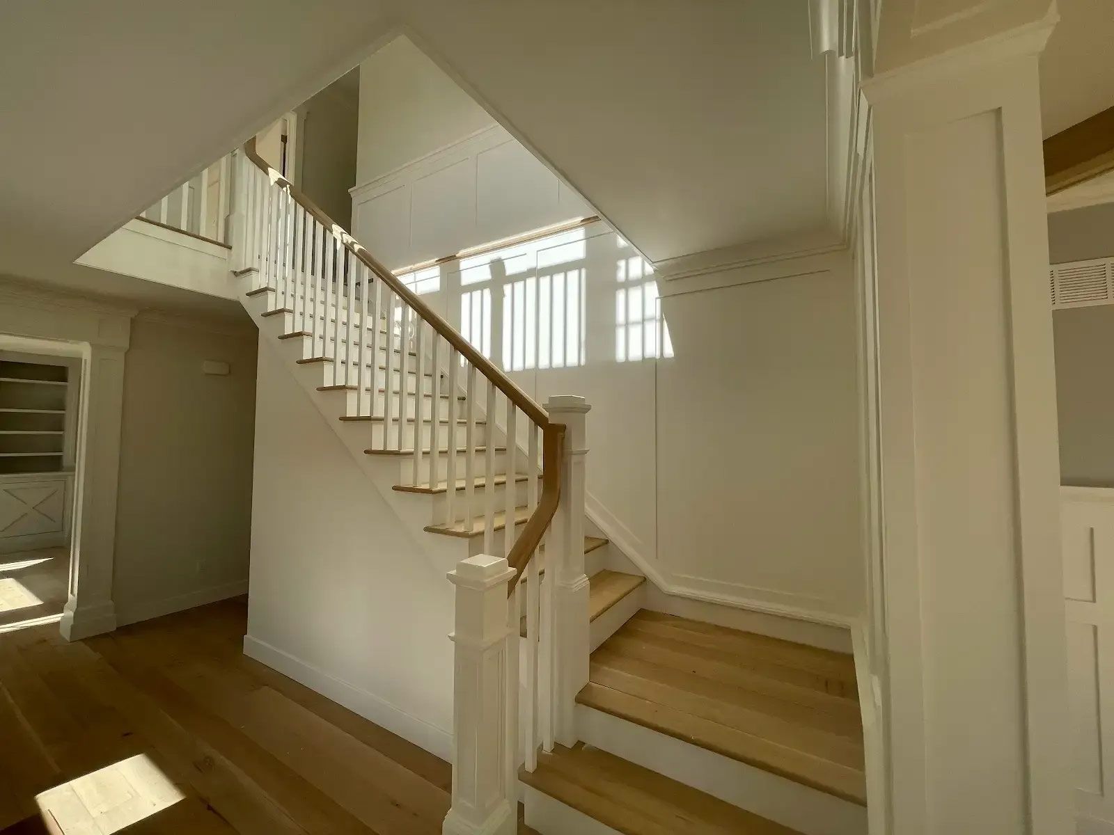 A staircase with white railings and wooden steps in a house