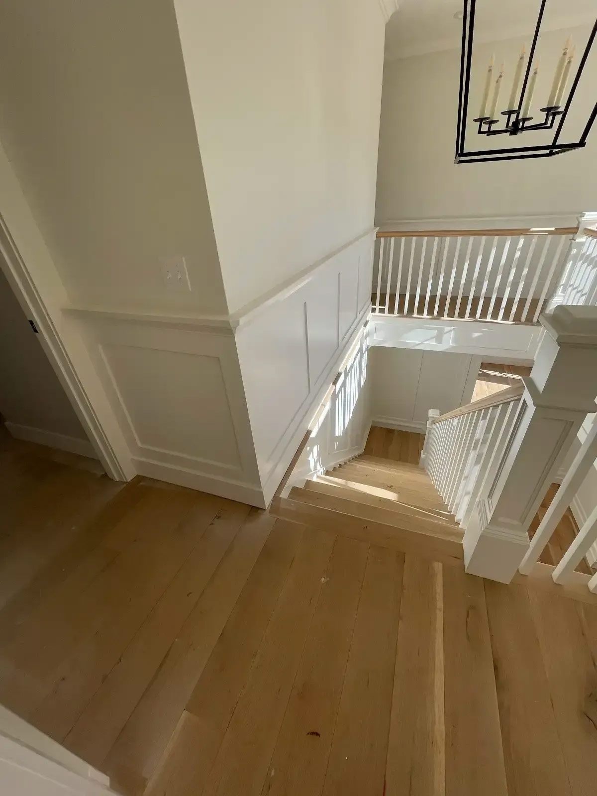 A staircase with wooden steps and a white railing in a house