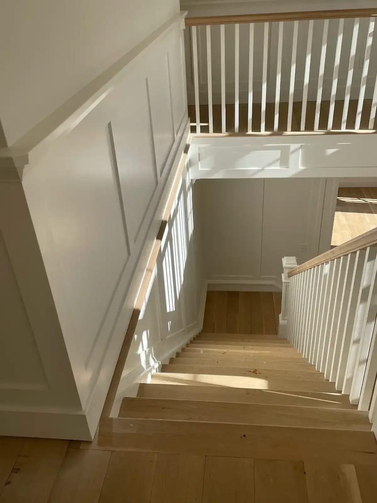 A wooden staircase with a white railing in a house