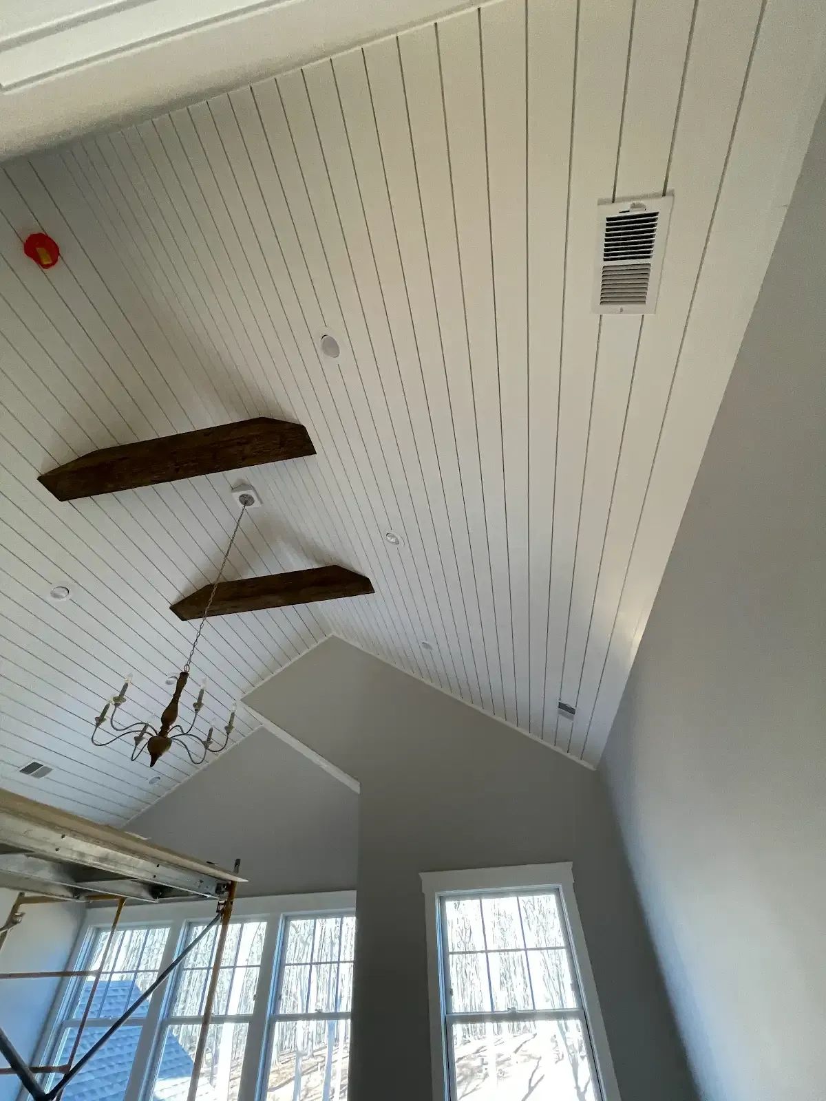 A room with a vaulted ceiling and a chandelier hanging from it