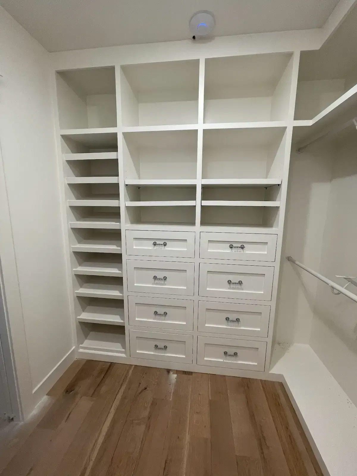 A walk in closet with lots of shelves and drawers