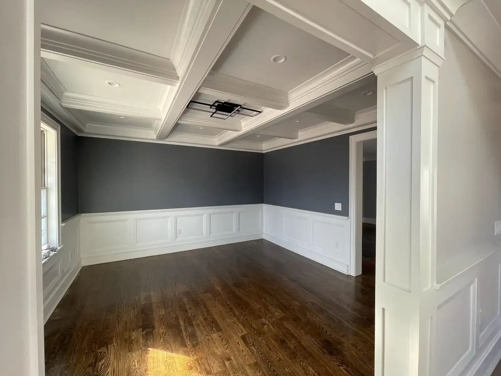 An empty room with hardwood floors and a ceiling fan
