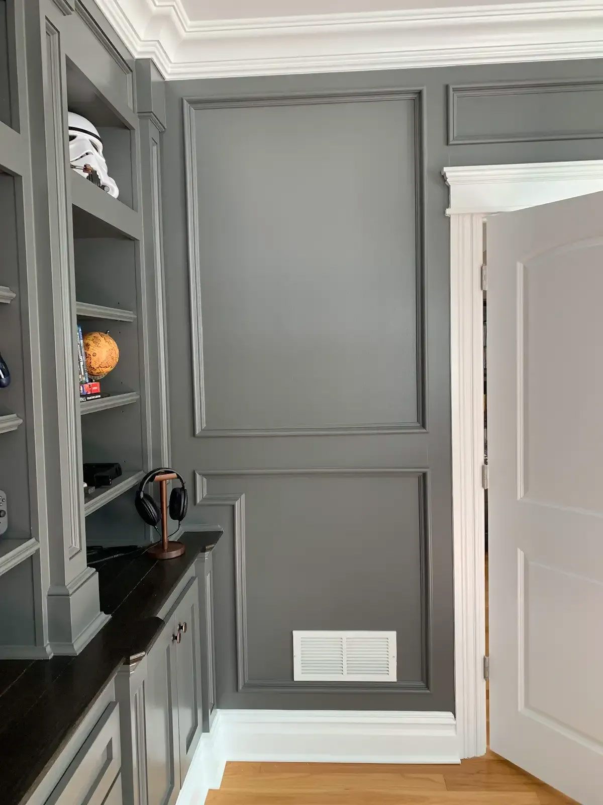 A room with gray walls and white trim and a door