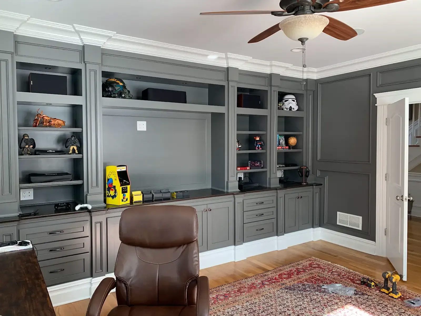 A living room with a ceiling fan and a chair