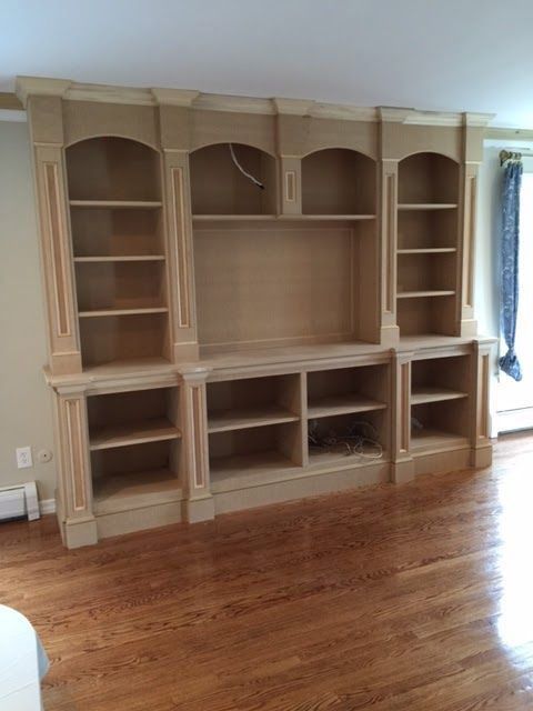 A living room with hardwood floors and a wooden entertainment center