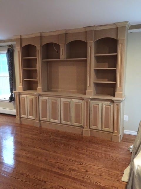 A living room with hardwood floors and a large wooden entertainment center