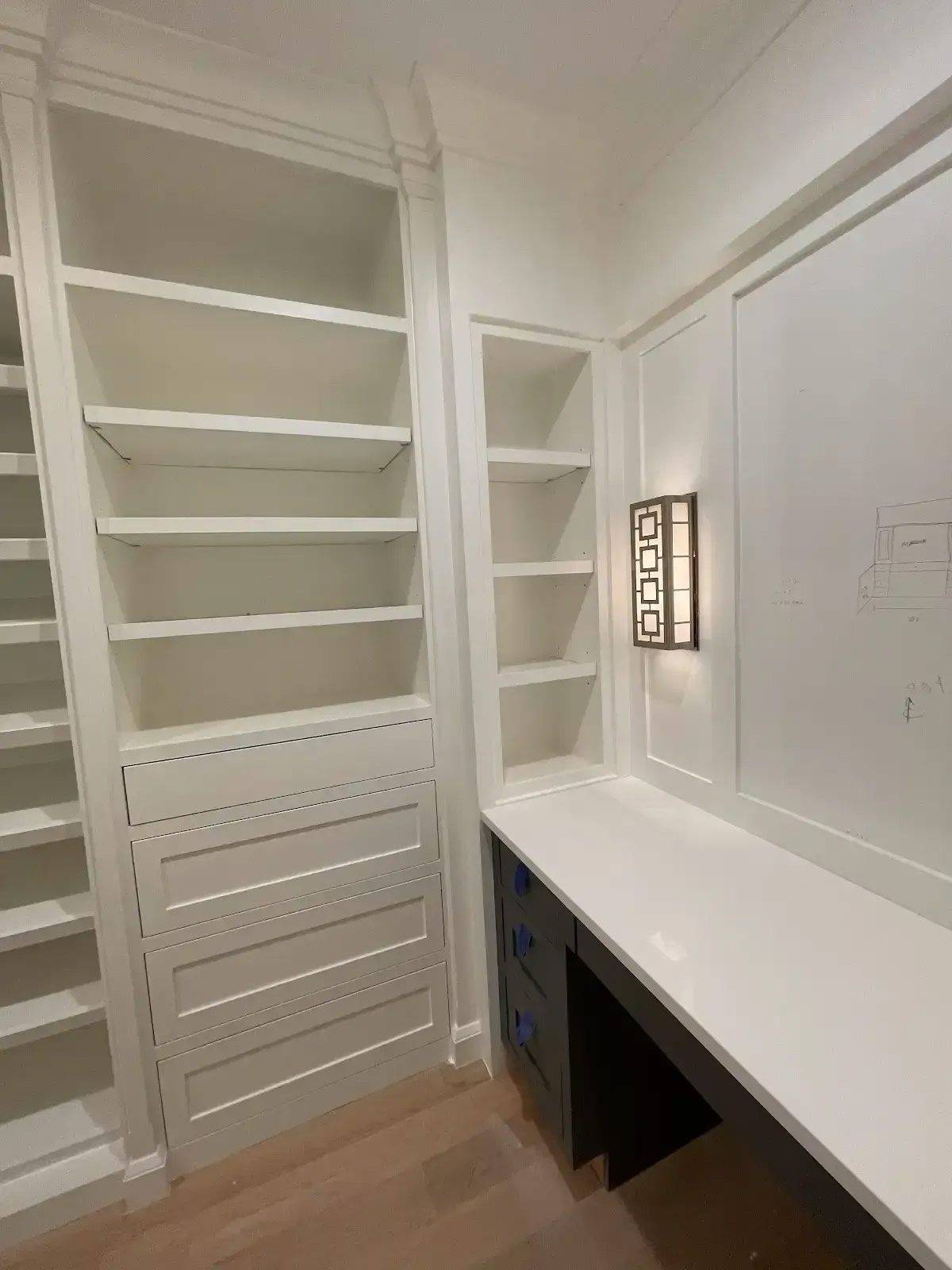 A closet with lots of shelves and a desk