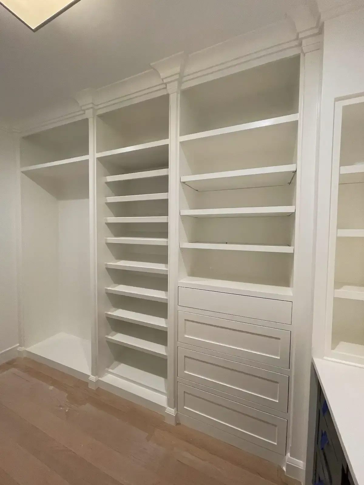 A walk in closet with lots of shelves and drawers
