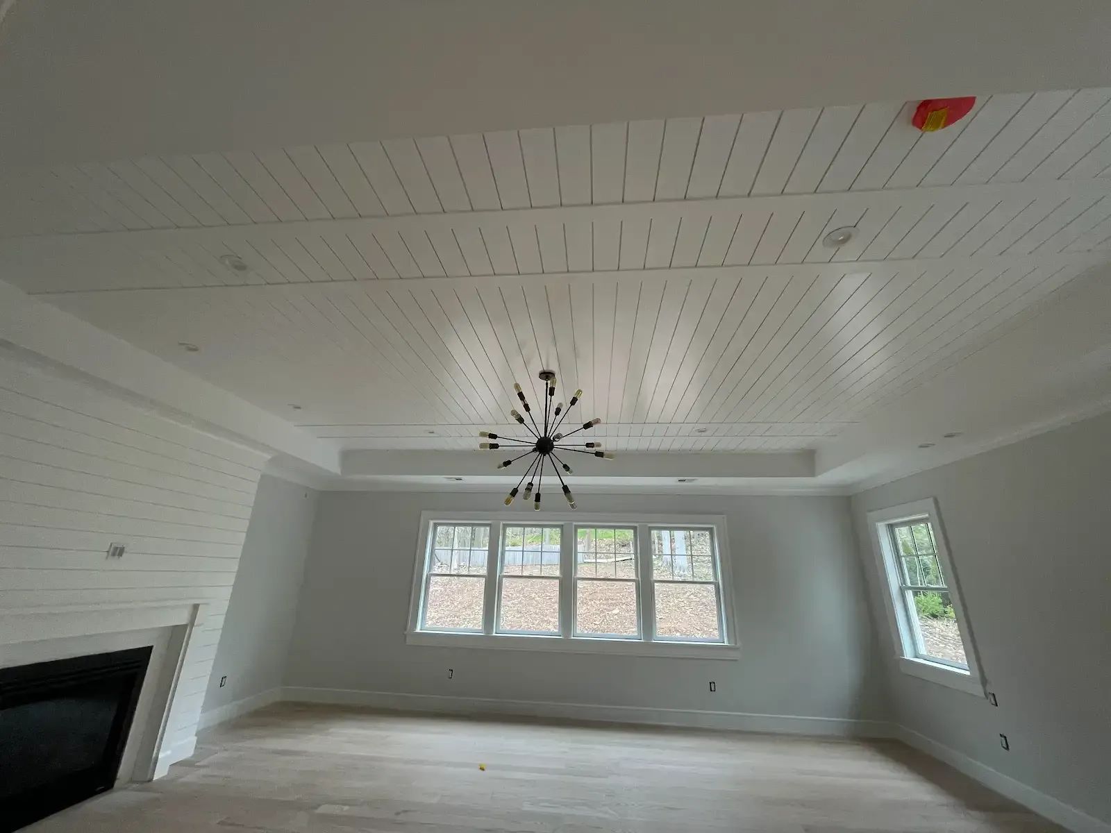 A living room with a fireplace and a chandelier hanging from the ceiling