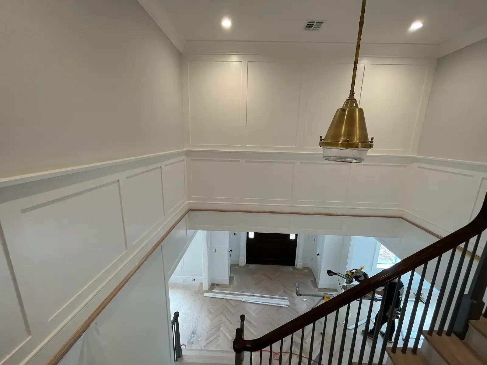A staircase in a house with a chandelier hanging from the ceiling