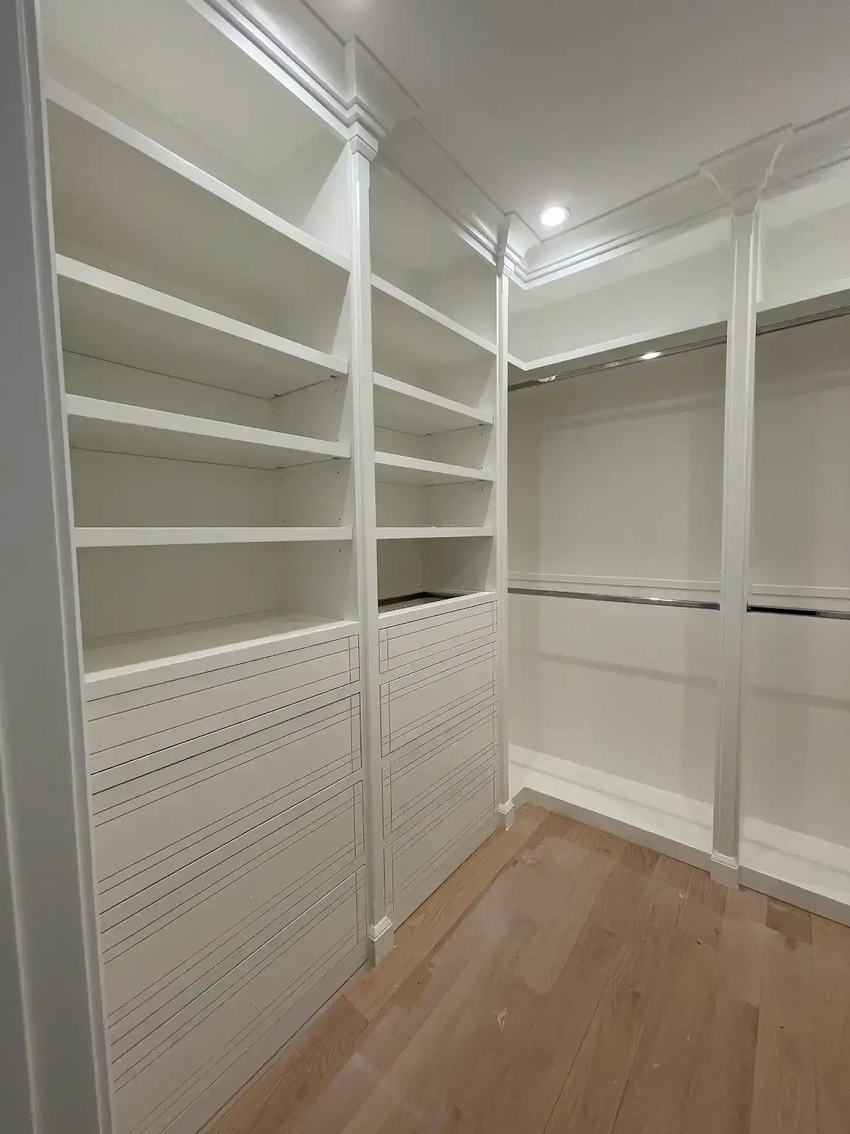 A walk in closet with lots of shelves and drawers