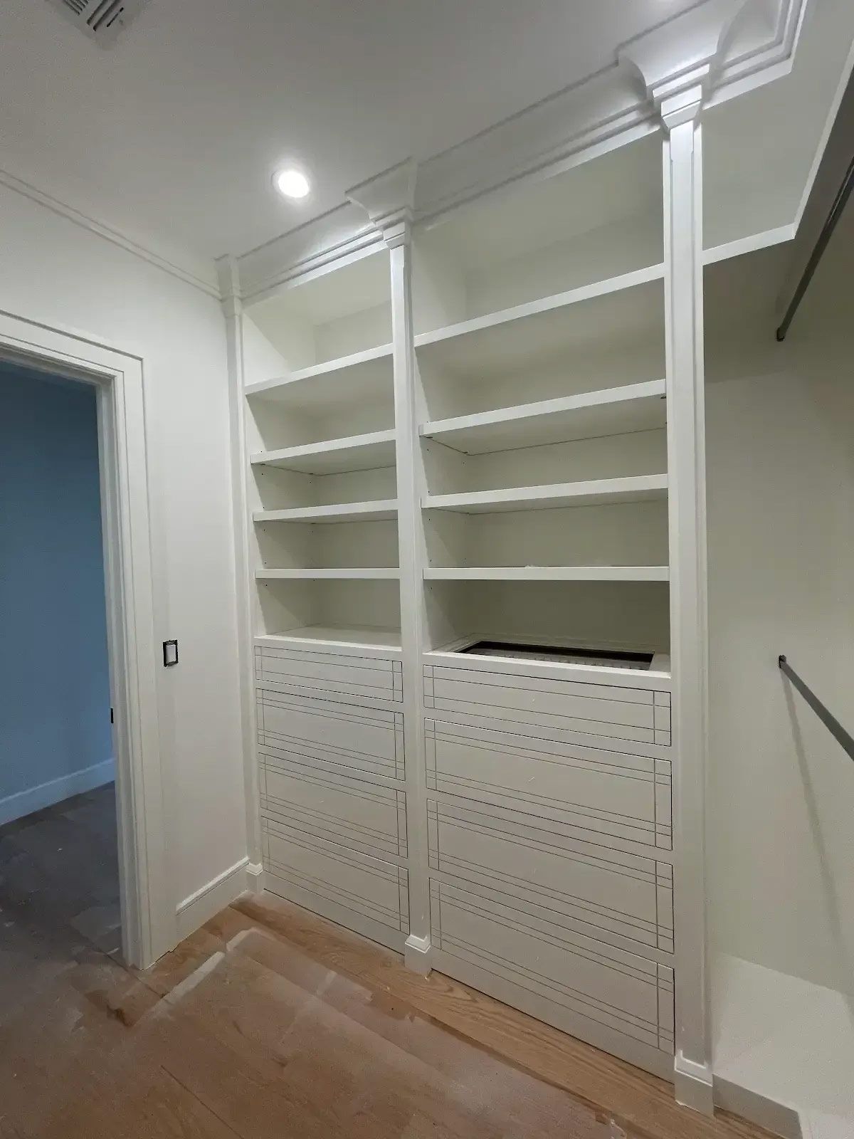 A walk in closet with lots of shelves and drawers