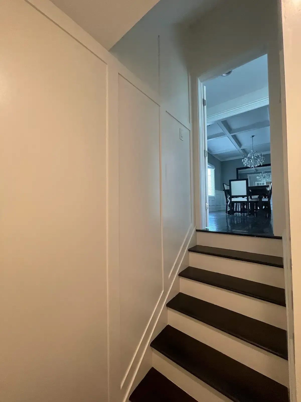 A hallway with stairs leading up to a living room