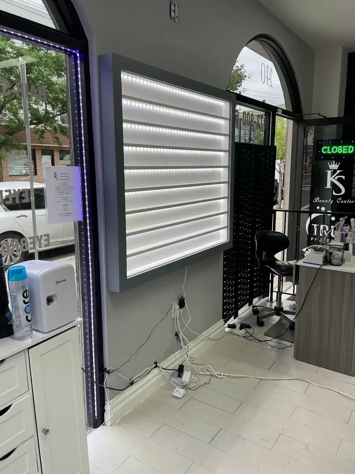 A salon with a large window and a display case on the wall