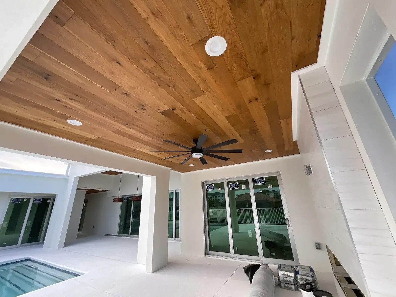 A living room with a wooden ceiling and a ceiling fan