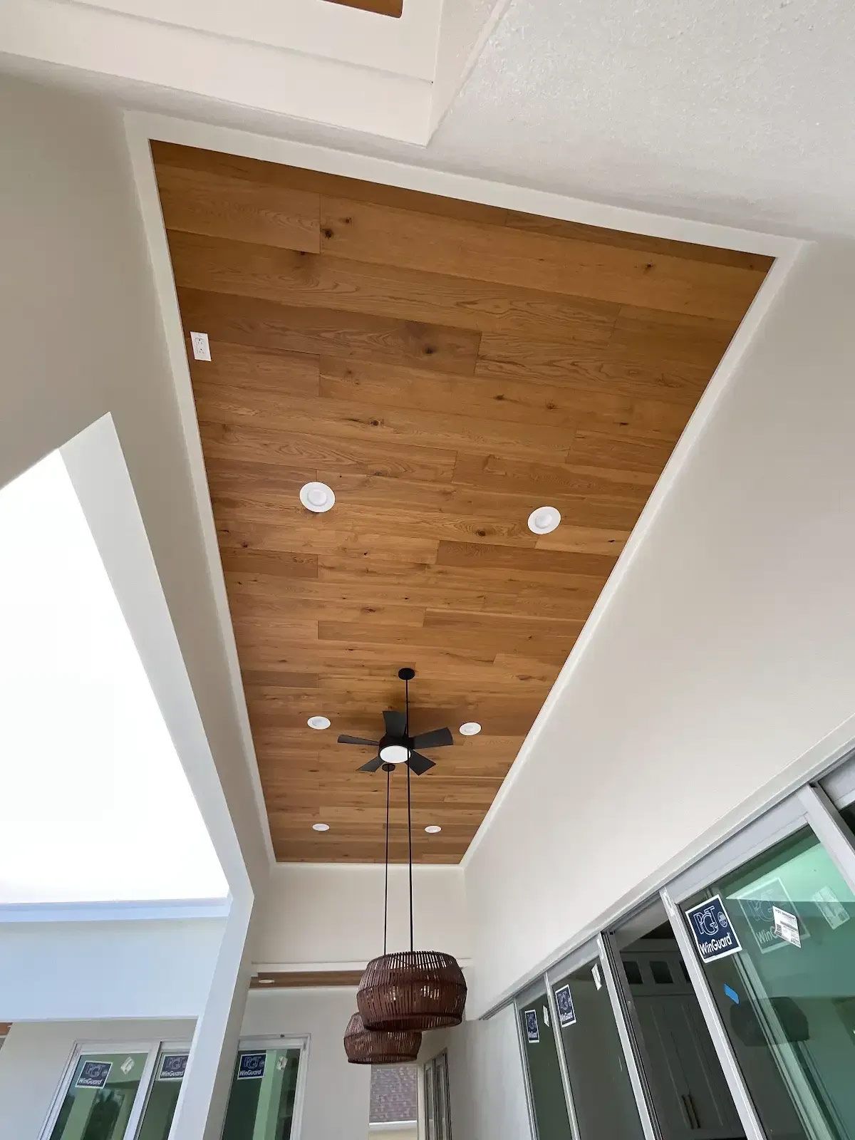 A wooden ceiling with a ceiling fan hanging from it