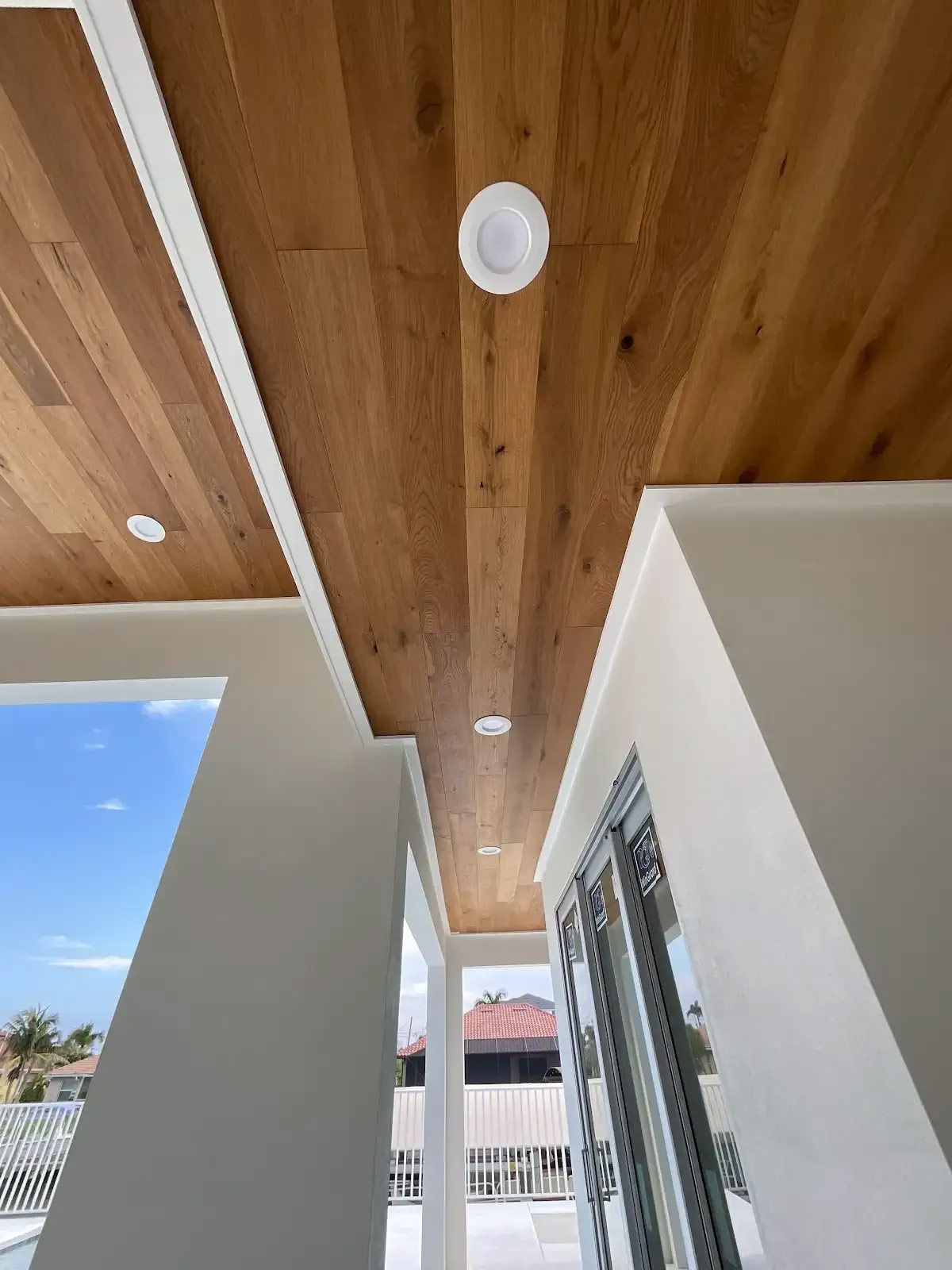 A balcony with a wooden ceiling and white walls